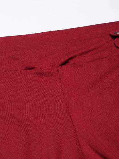 Maroon pant fabric close-up with button placket at adjustable waist